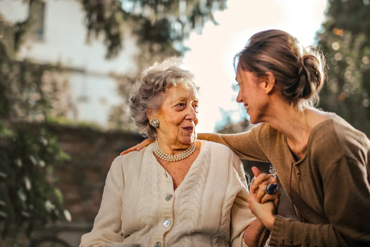 gum disease and Alzheimer's disease - senior woman holding hands with daughter