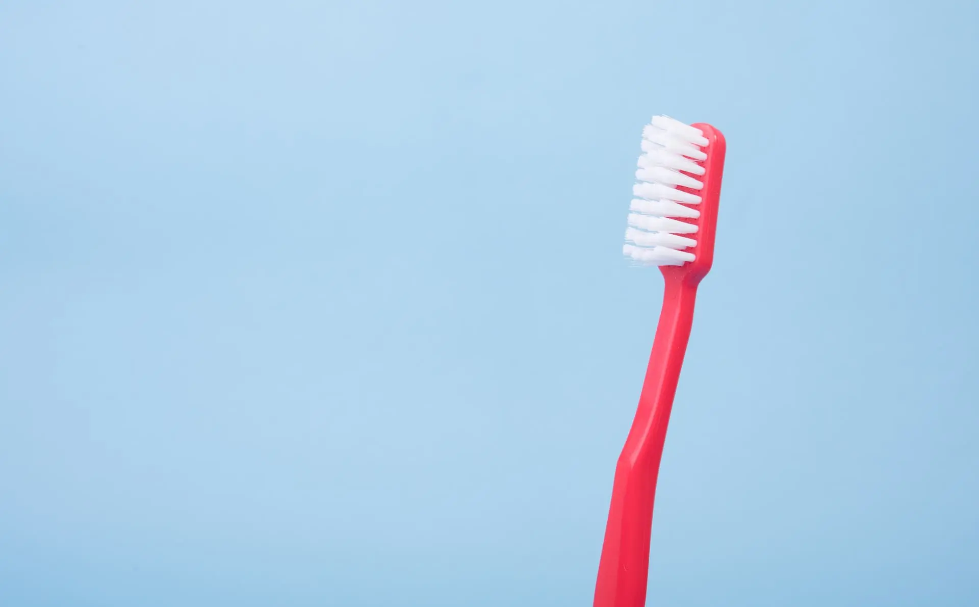 red toothbrush on blue background