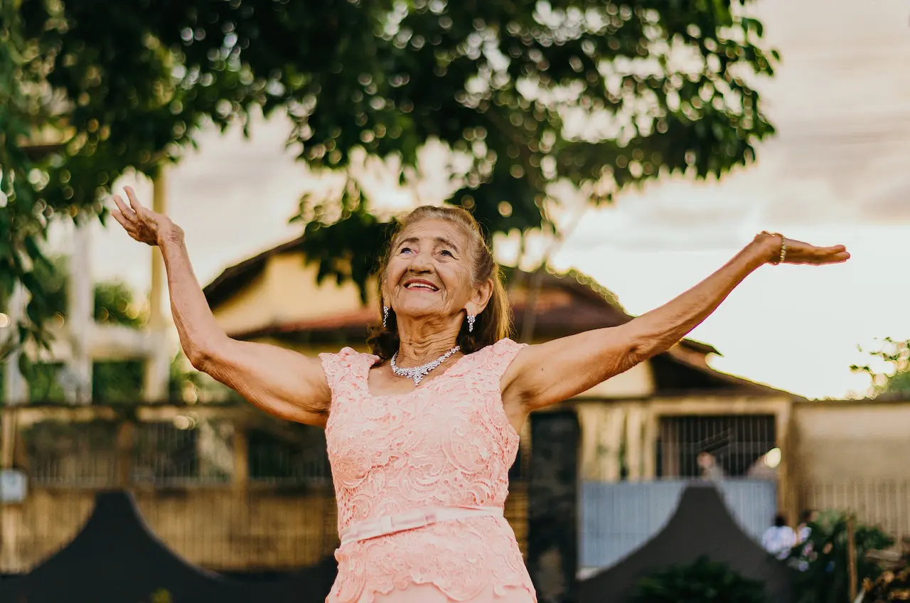 woman in formal pink dress raising her hands