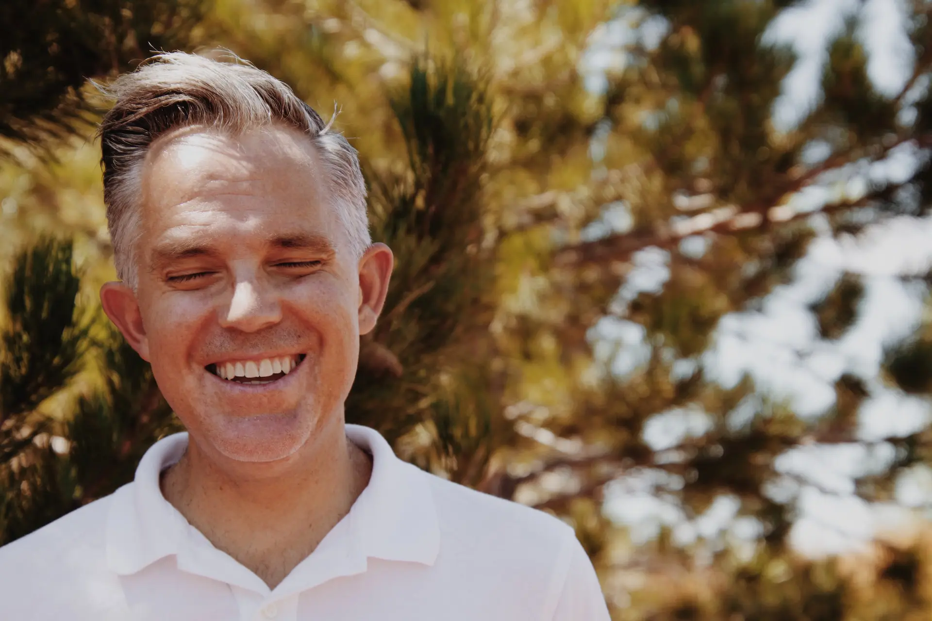 can senior teeth be whitened; man with eyes closed smiling outdoors