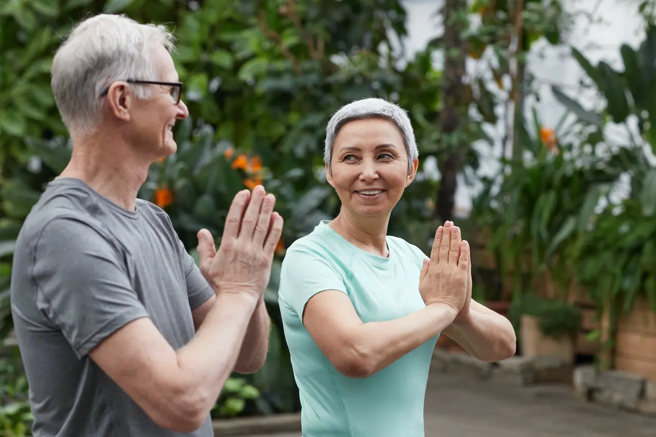 man and woman smiling doing yoga