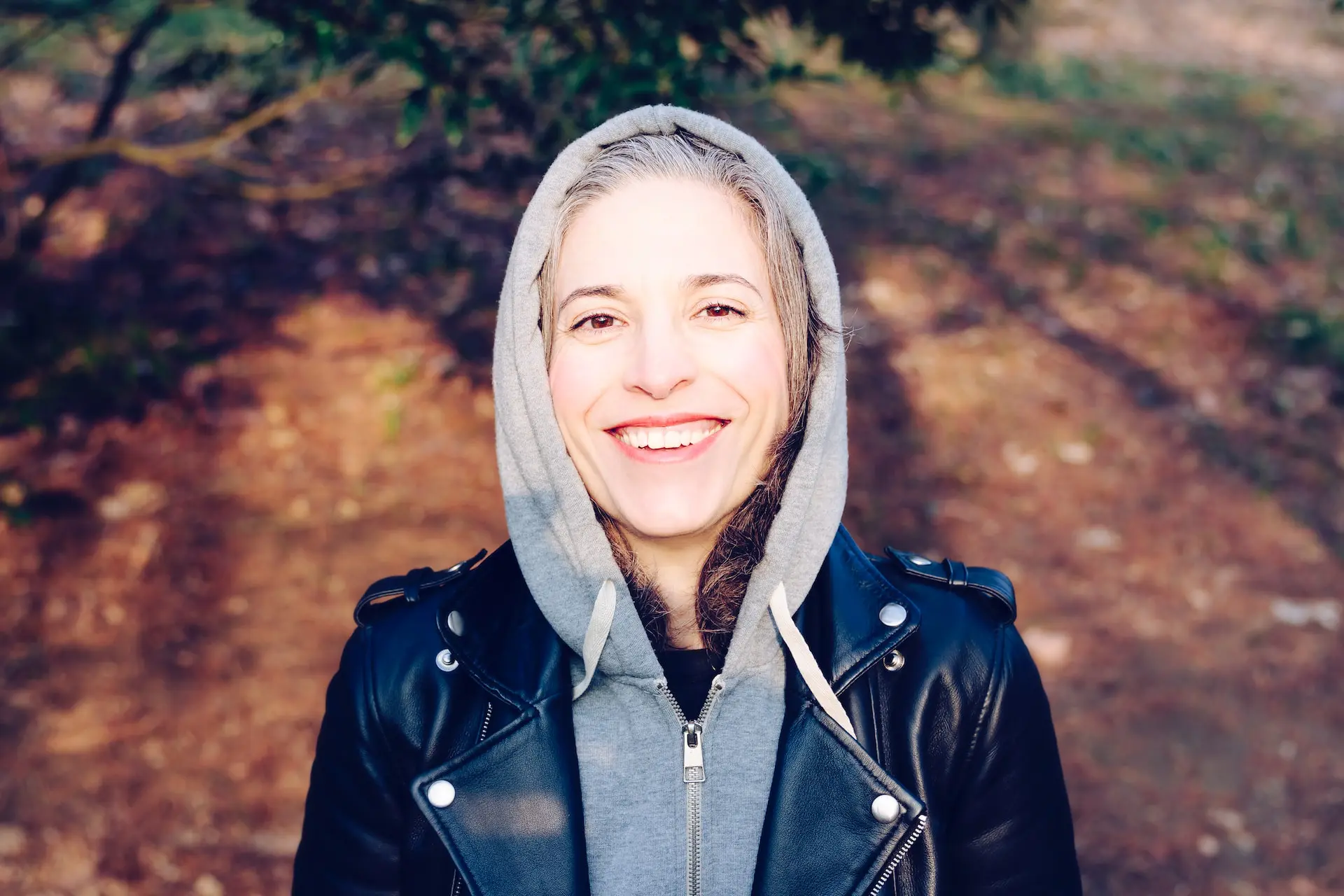 older woman in hoodie smiling at camera