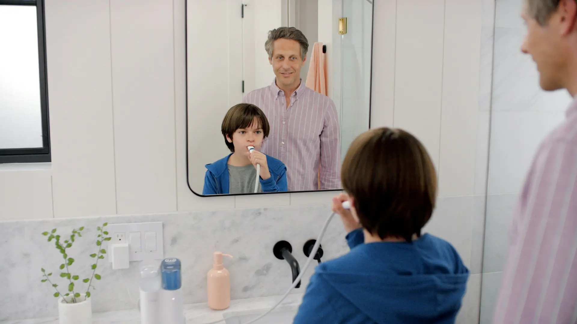 child brushing teeth in a mirror