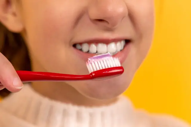 smiling girl with toothbrush and toothpaste for preventive dental care