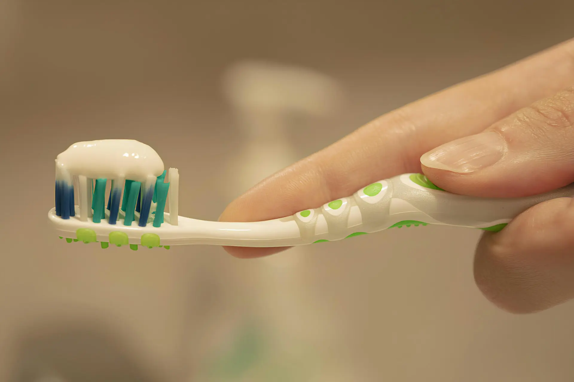 hand holding a toothbrush with toothpaste