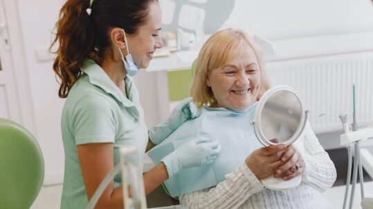 cosmetic dentistry for older adults - older woman smiling in dentist's chair