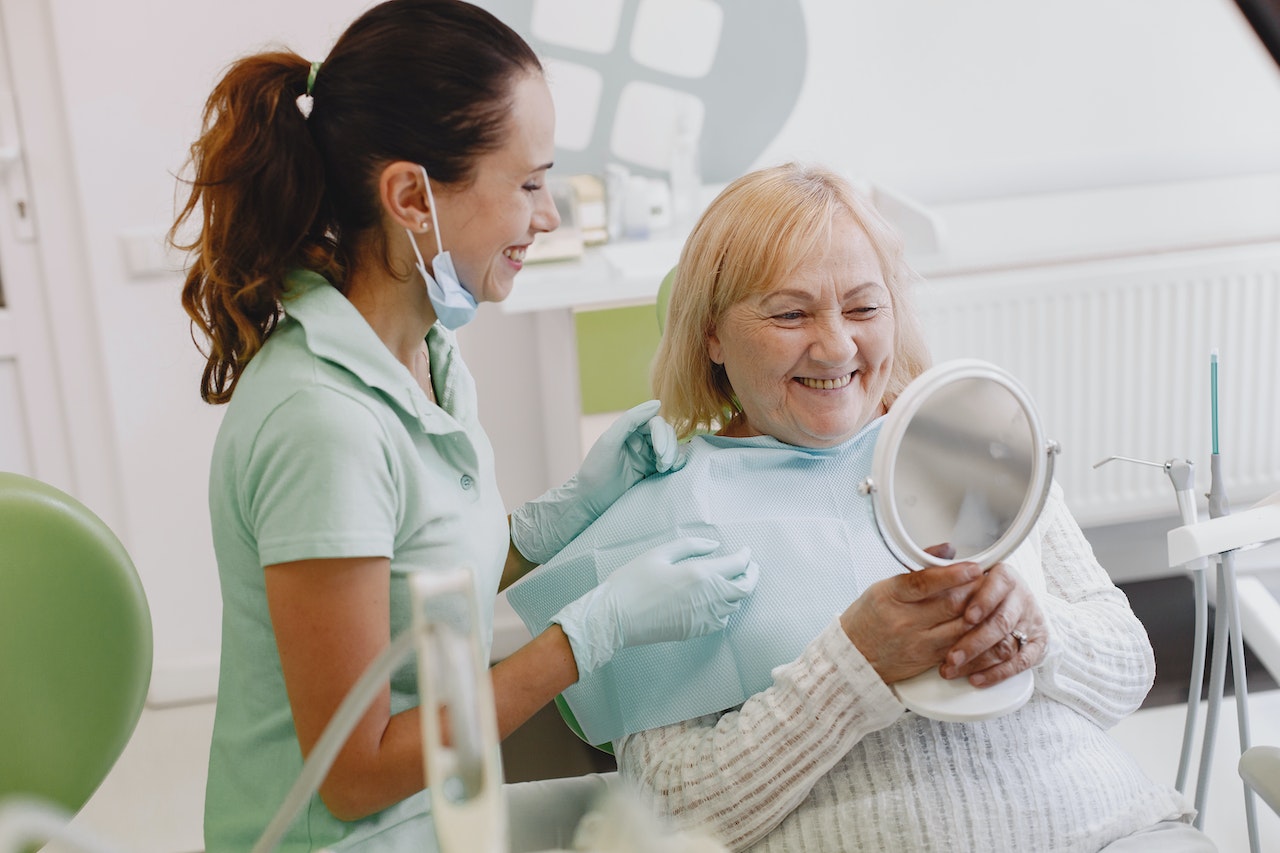 cosmetic dentistry for older adults - older woman smiling in dentist's chair