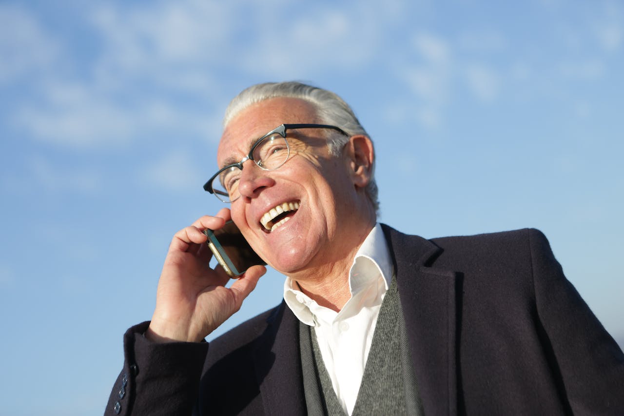 older man talking on phone and smiling