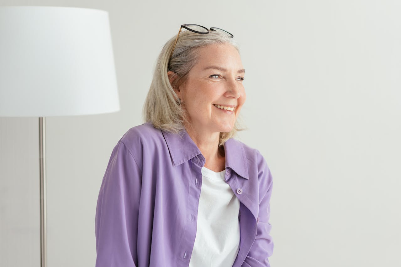 older woman in purple shirt smiling